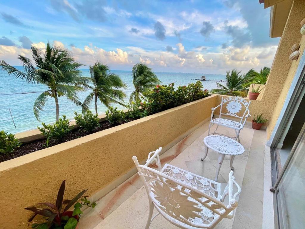 a balcony with two chairs and a view of the ocean at All Ritmo by Andiani Travel in Cancún