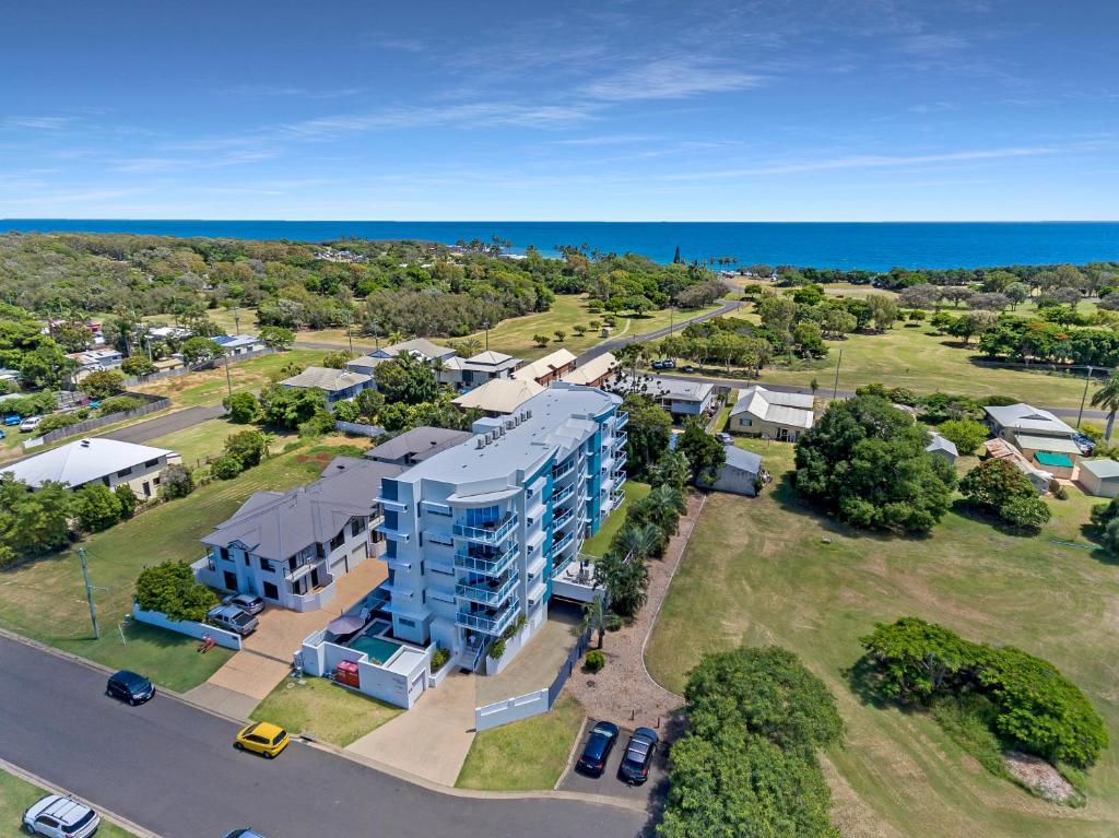 an aerial view of a building with the ocean in the background at Koola Beach Apartments Bargara in Bargara