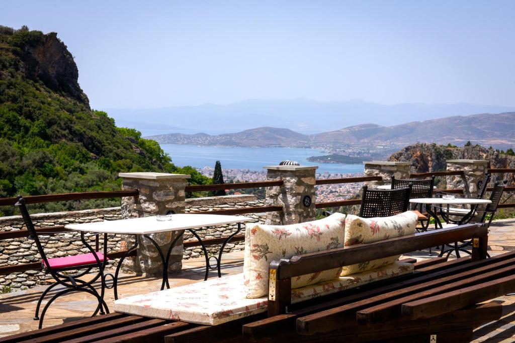 a patio with tables and chairs and a view of the ocean at Archontiko Argyro in Makrinitsa