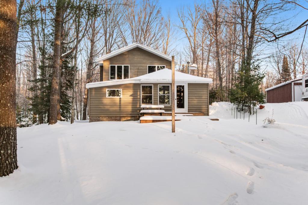een klein huis in de sneeuw in een tuin bij Cabin on the Loop-Upper in Three Lakes