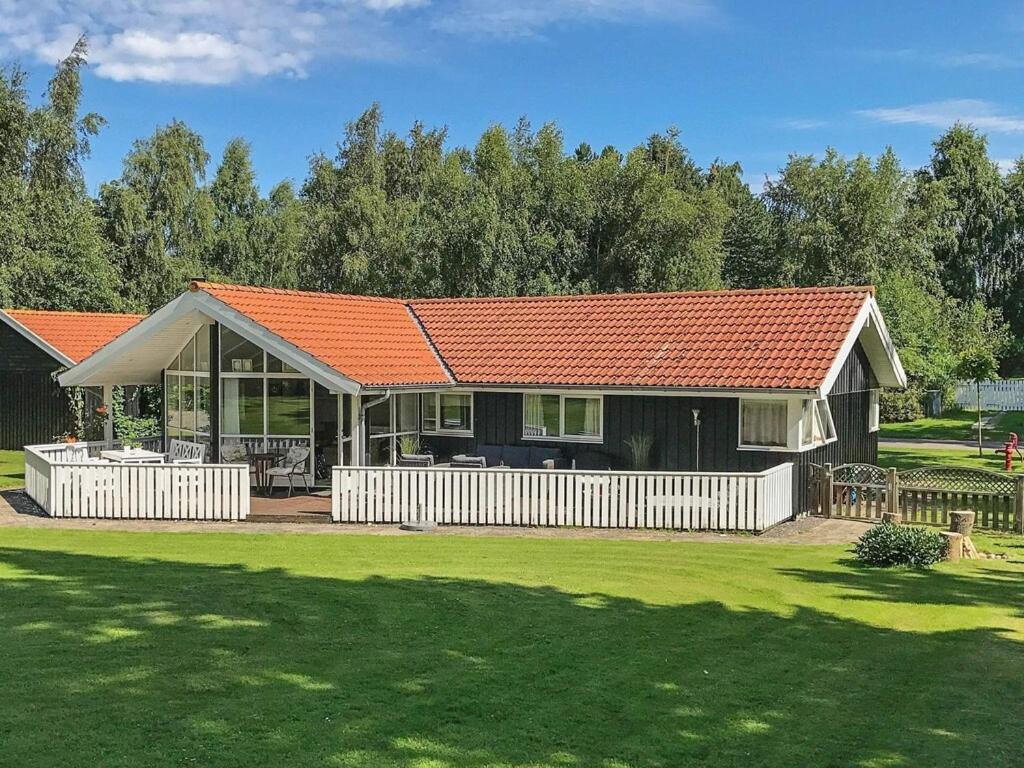 GræstedにあるHoliday Home Kolninggårdarnaのオレンジの屋根と庭のある家