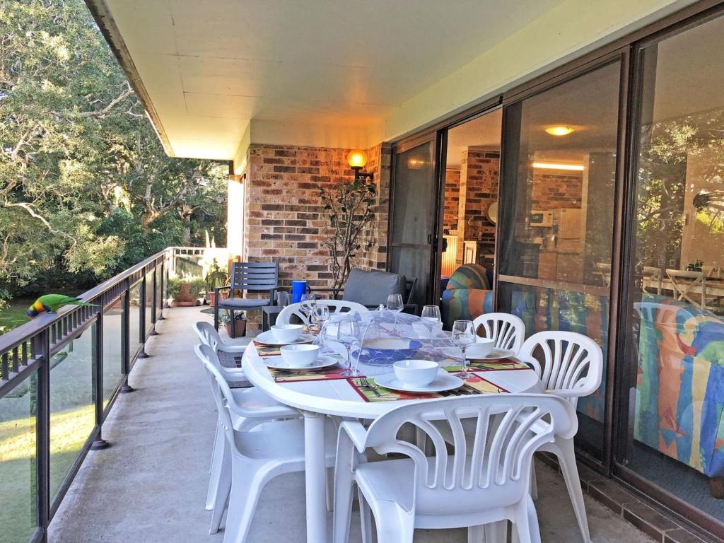 - Balcón con mesa blanca y sillas en Bay Parklands, 62 2 Gowrie Avenue - Wifi, Pool, Tennis, Water Views & Aircon, en Nelson Bay