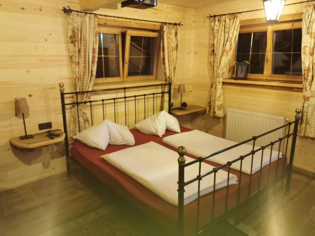 1 Schlafzimmer mit 2 Betten, einem Tisch und Fenstern in der Unterkunft Kaiserhaus Harald Astner Ebbs Studio 1 in Ebbs
