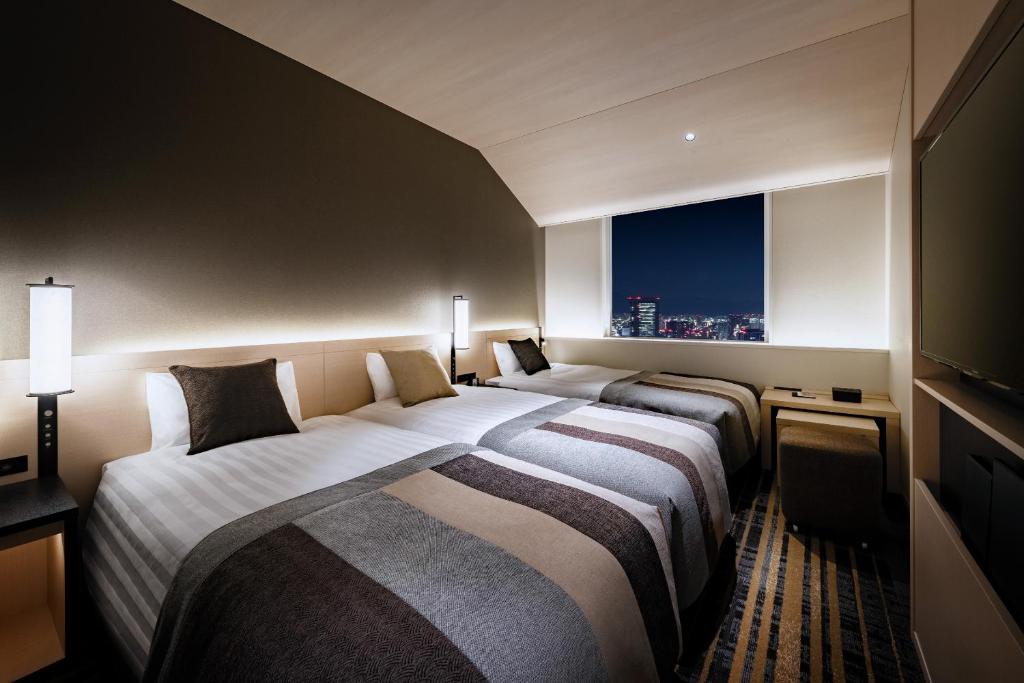 Postel nebo postele na pokoji v ubytování Hotel Hankyu RESPIRE OSAKA