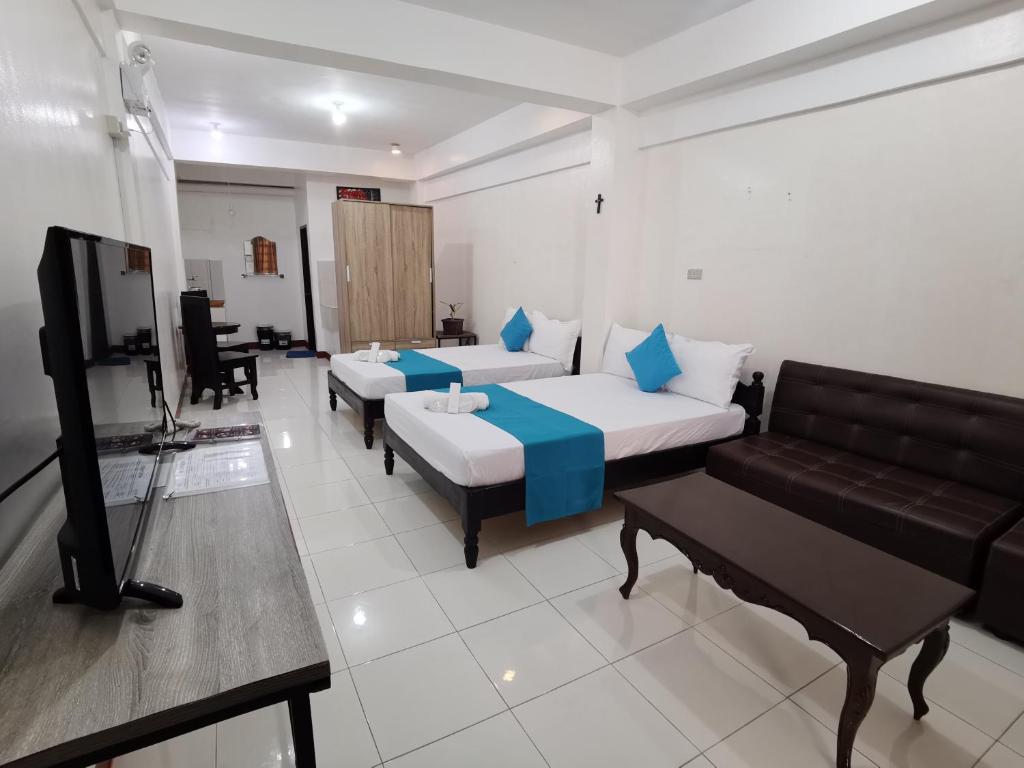 uma sala de estar com duas camas e um sofá em JPrime Apartelle em Tuguegarao City