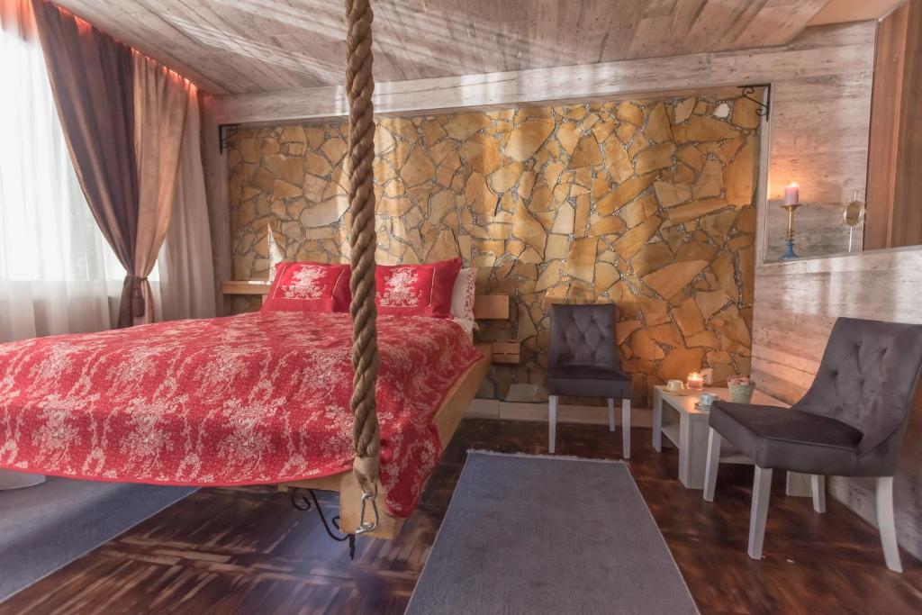 1 dormitorio con cama y pared de piedra en Onore dell'amore 2 en Banja Koviljača
