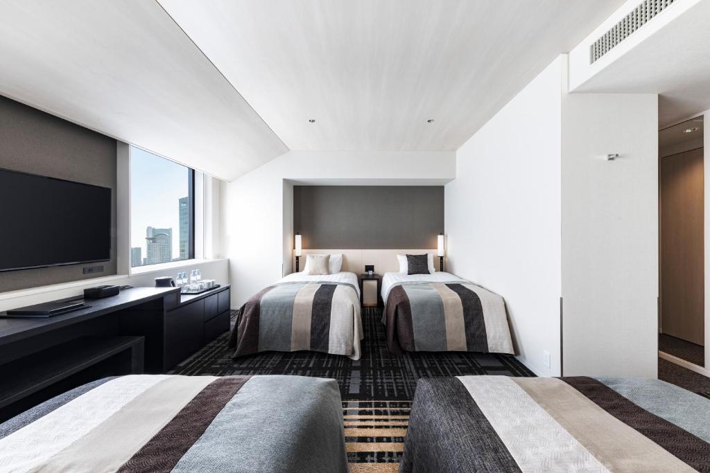 Postel nebo postele na pokoji v ubytování Hotel Hankyu RESPIRE OSAKA