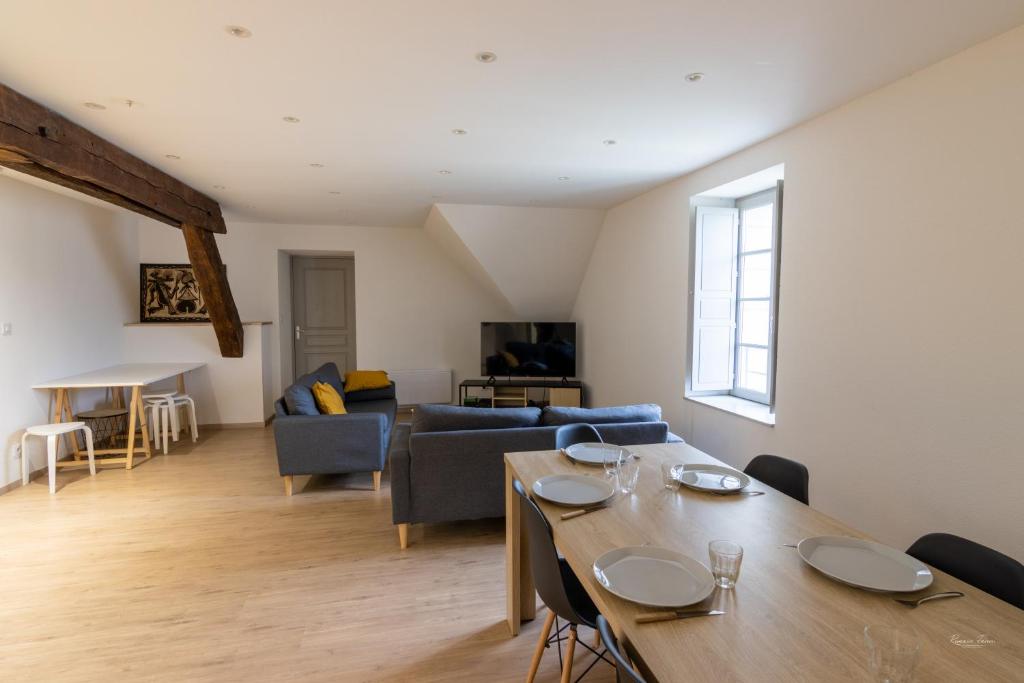 uma sala de estar com uma mesa e um sofá em Magnifique appartement rénové dans résidence em Saumur
