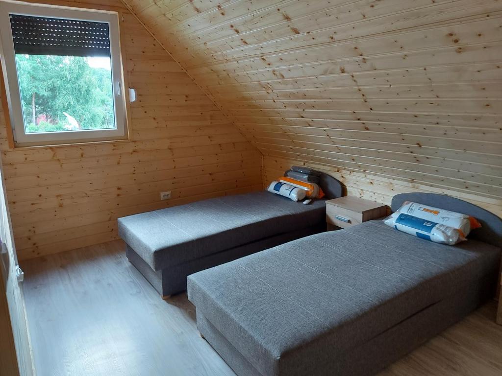 - une chambre avec 2 lits et une fenêtre dans une cabine dans l'établissement Dom NARIE na Mazurach nad Jeziorem Narie, à Bogaczewo