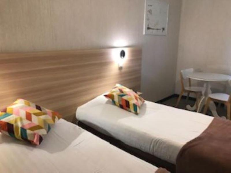 a hotel room with two beds and a table at Auberge De Moricq in Angles