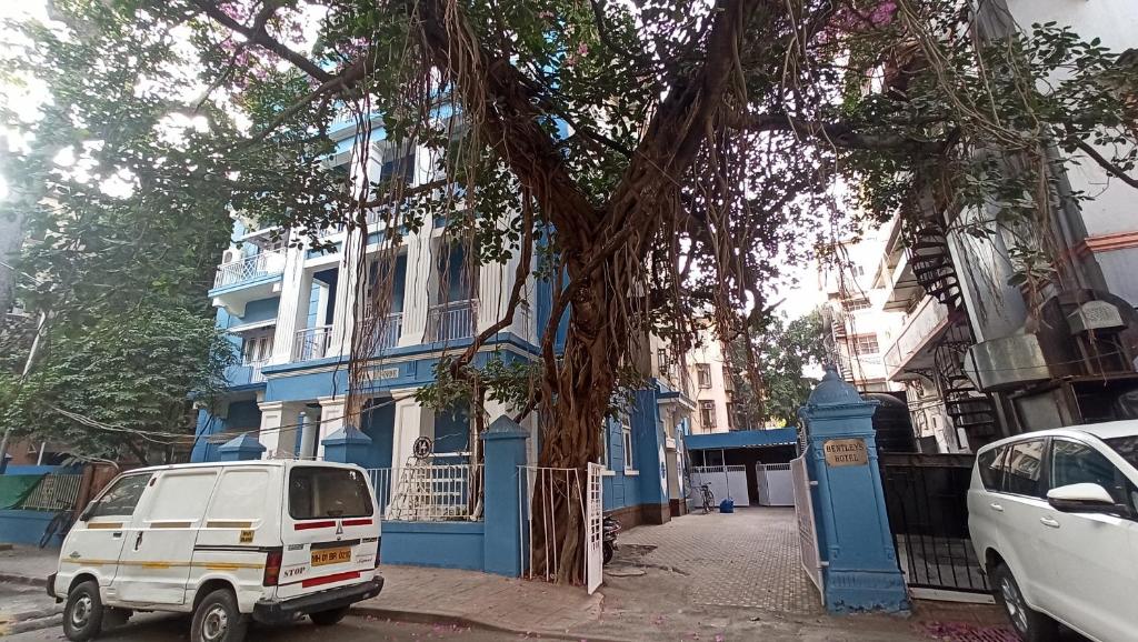 a white van parked in front of a blue building at Bentleys Hotel in Mumbai