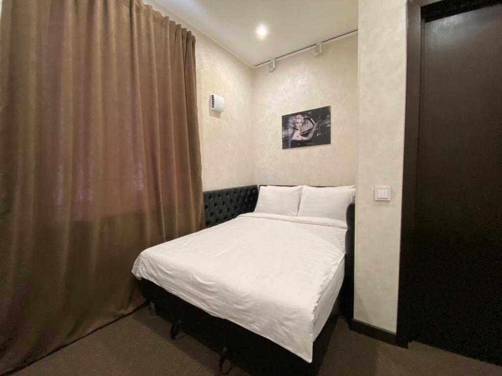 Отель Декабрист на Промышленной 60 في تشيتا: غرفة نوم صغيرة مع سرير مع ملاءات بيضاء