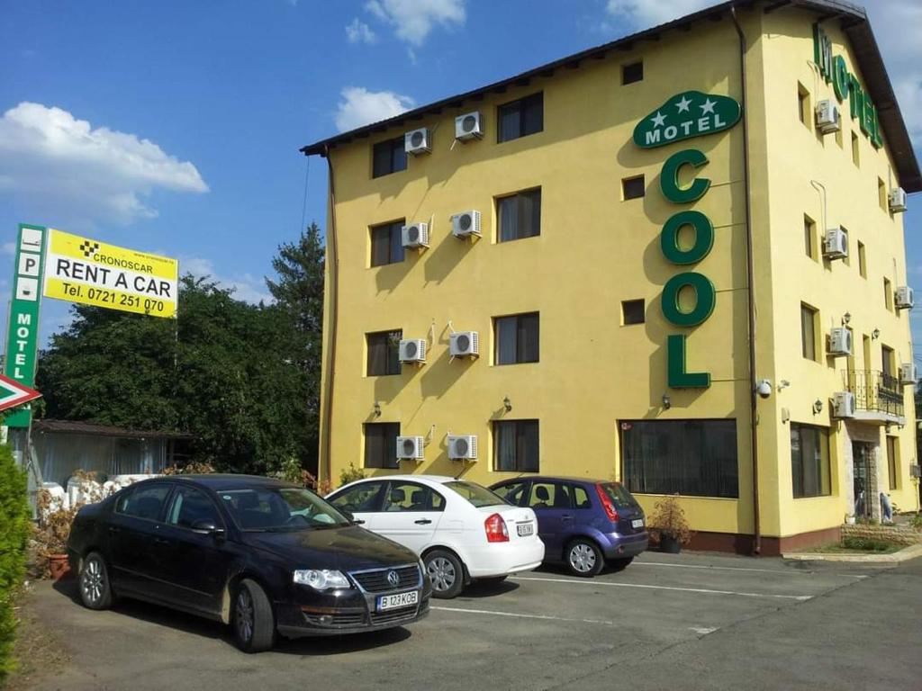 two cars parked in a parking lot in front of a hotel at MOTEL COOL in Bărcăneşti