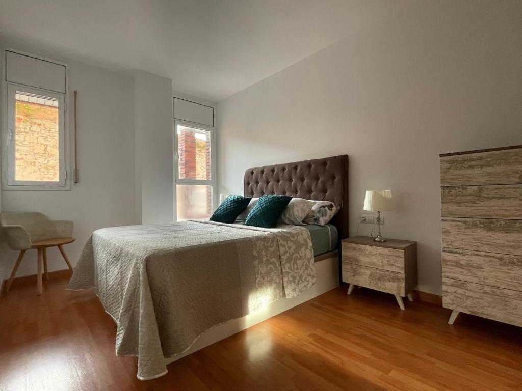 ein Schlafzimmer mit einem Bett mit blauen Kissen darauf in der Unterkunft Tarraco Apartment in Tarragona