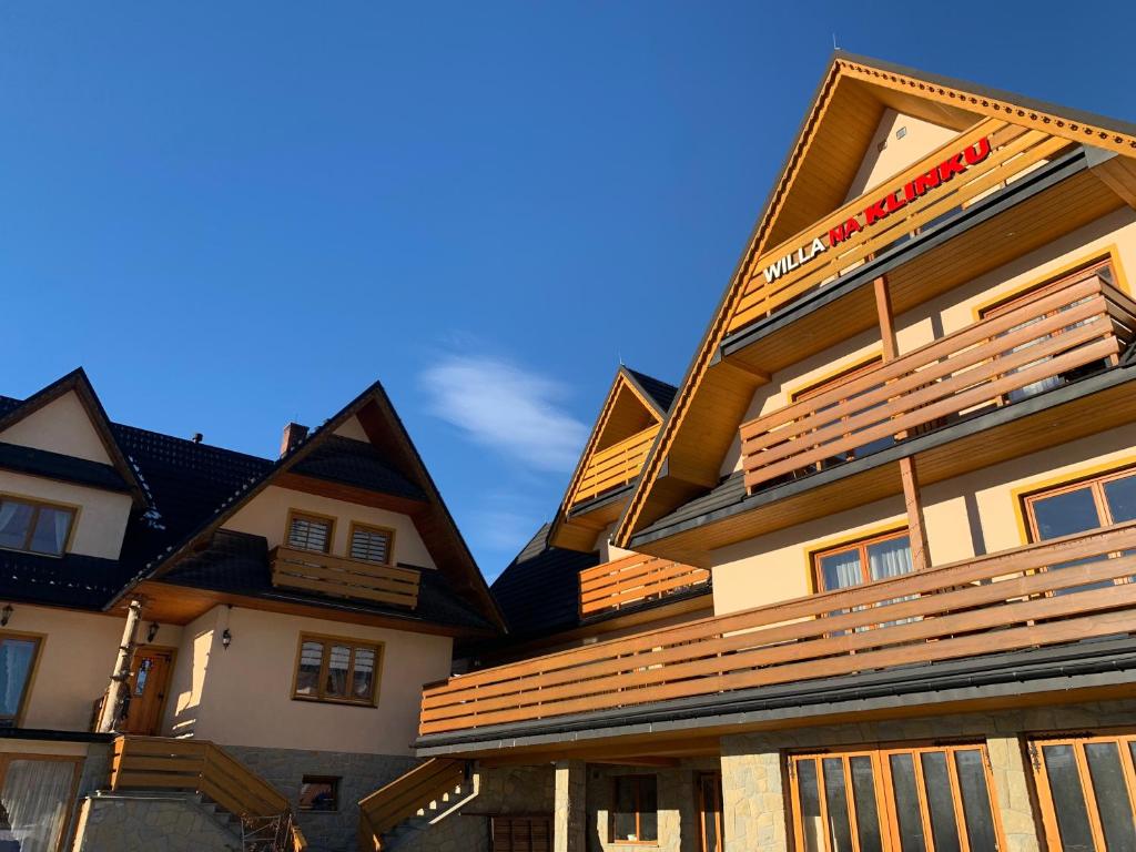 a building with wooden shingles on top of it at Willa "NA KLINKU" in Dzianisz