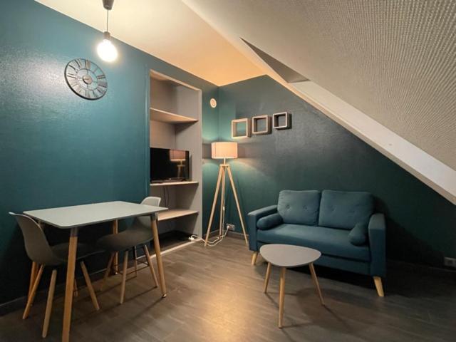 un salon avec un canapé bleu et une table dans l'établissement Appartement Huanlili, à Noyers-sur-Cher