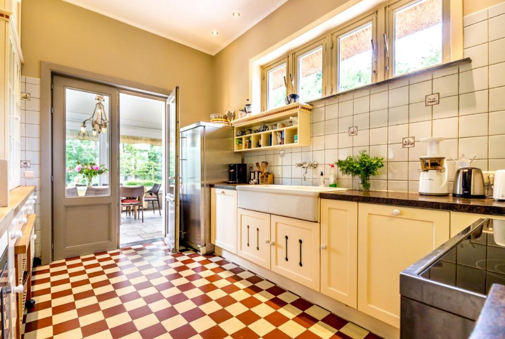 a kitchen with yellow cabinets and a checkered floor at Raesborre in Leuven
