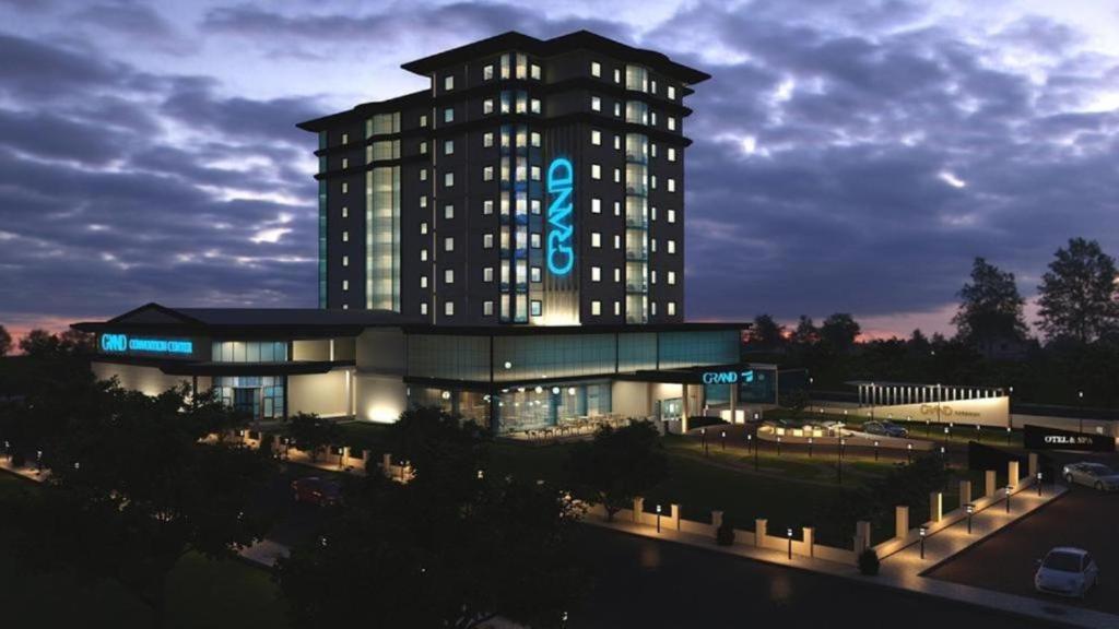 un bâtiment avec un panneau la nuit dans l'établissement Grand Hotel & Convention Center Karaman, à Karaman