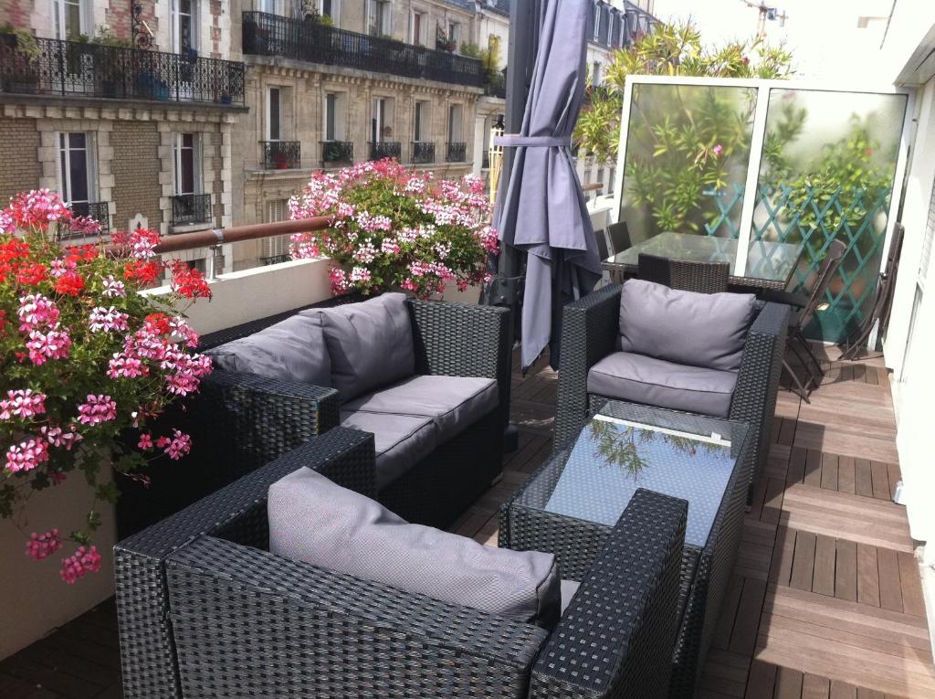 - un balcon avec des chaises, des tables et des fleurs dans l'établissement Chambre d'Amis, à Paris