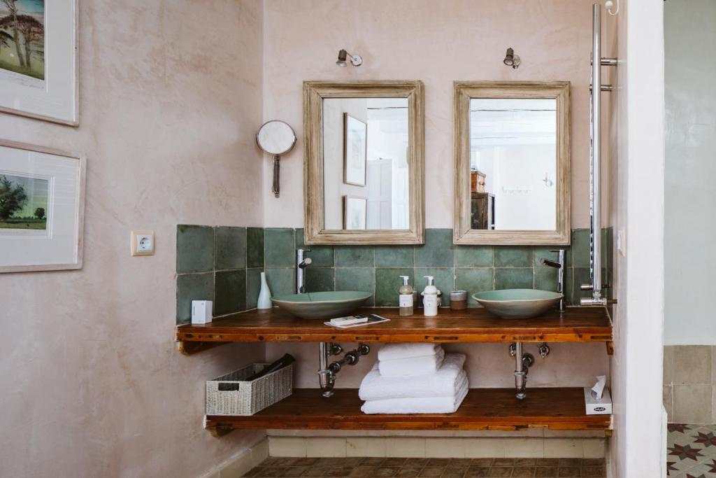 a bathroom with two sinks and two mirrors at Casa La Siesta in Vejer de la Frontera