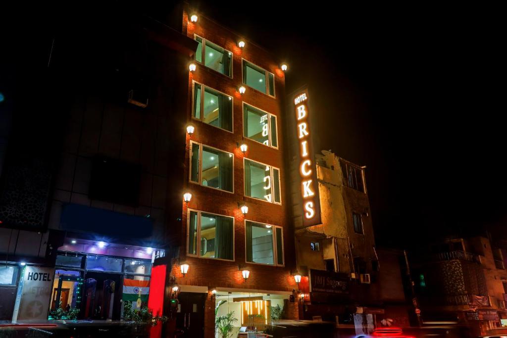 un bâtiment avec un panneau de néon sur son côté dans l'établissement Hotel Bricks, Karol Bagh, New Delhi, à New Delhi