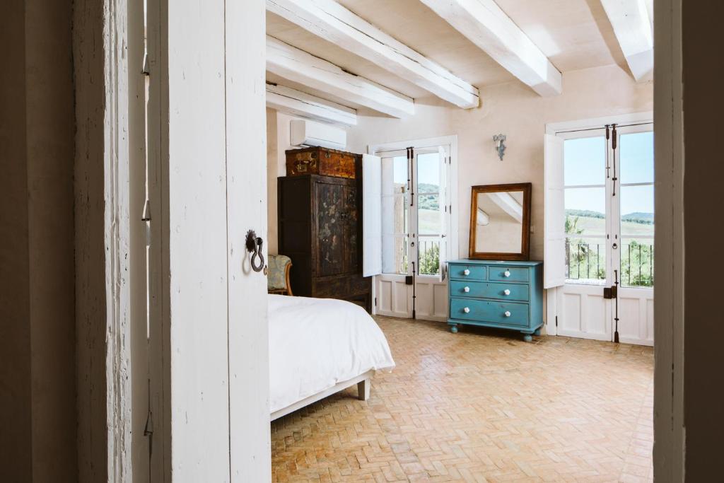 a bedroom with a bed and a dresser and windows at Casa La Siesta in Vejer de la Frontera