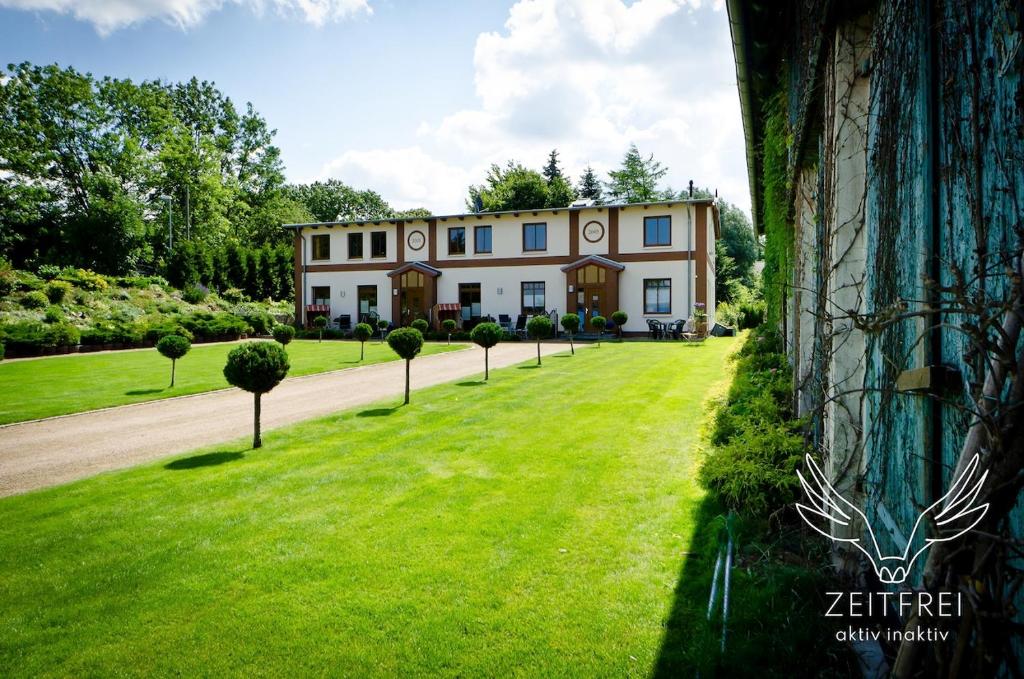 a large house with a green lawn in front of it at ZEITFREI Urlaubsappartememts & Veranstaltungsort in Steffenshagen