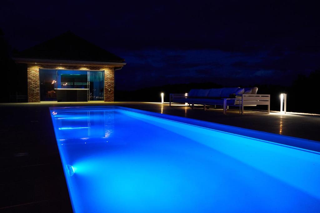 a swimming pool at night with blue lights at Château Boussas in Couloumé-Mondébat