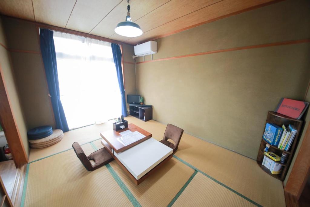 - une table et deux chaises dans une chambre avec fenêtre dans l'établissement ulala hometown - Vacation STAY 09297v, à Kagoshima