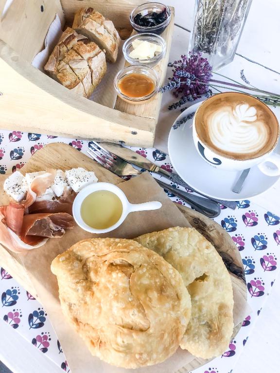 a table with a tray of pastries and a cup of coffee at Kisas Loft By Pinch in Pakoštane