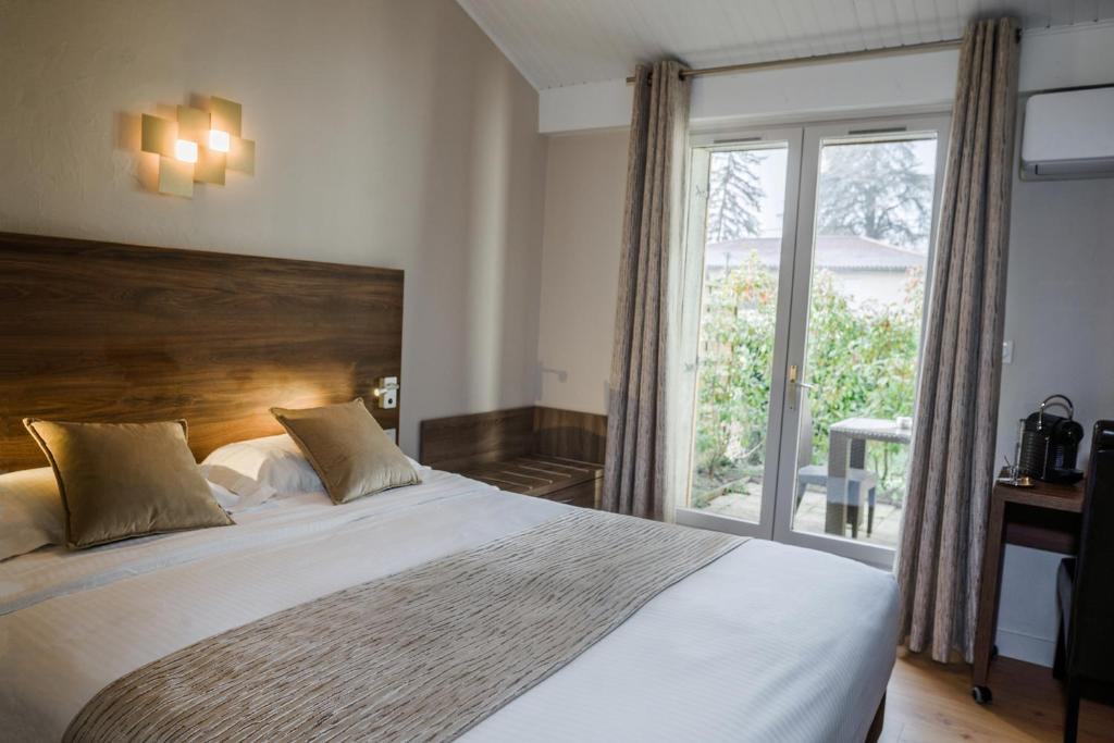 Postel nebo postele na pokoji v ubytování Logis Hotel Le Petit Casset