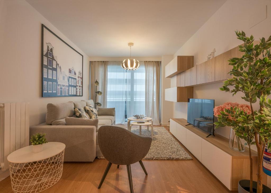 een woonkamer met een bank en een tv bij Goizeder apartment by People Rentals in Bilbao
