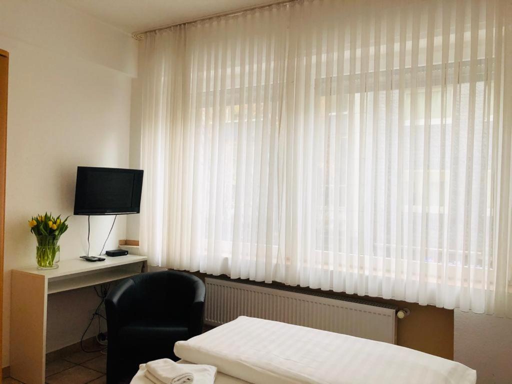 a hotel room with a bed and a desk and a window at Hotel im Brühler Hof in Brühl