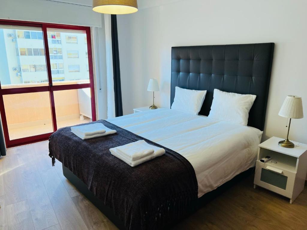 a bedroom with a large bed with two towels on it at Beautiful Apartment - Family and Group of Friends in Póvoa de Santa Iria