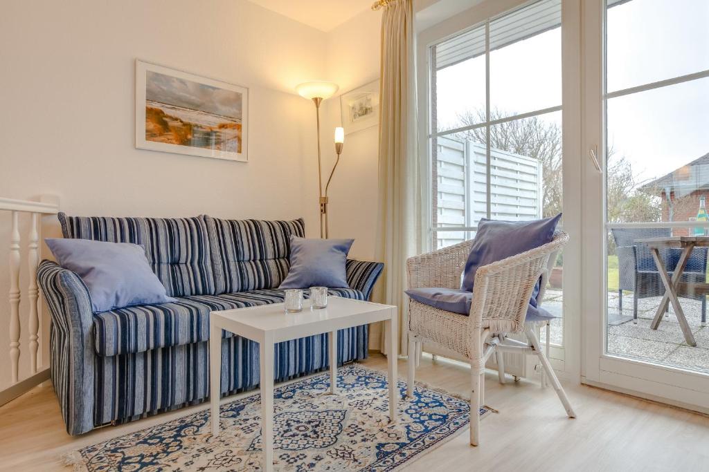 a living room with a couch and a table at Rosenkamp App 2 in Wenningstedt