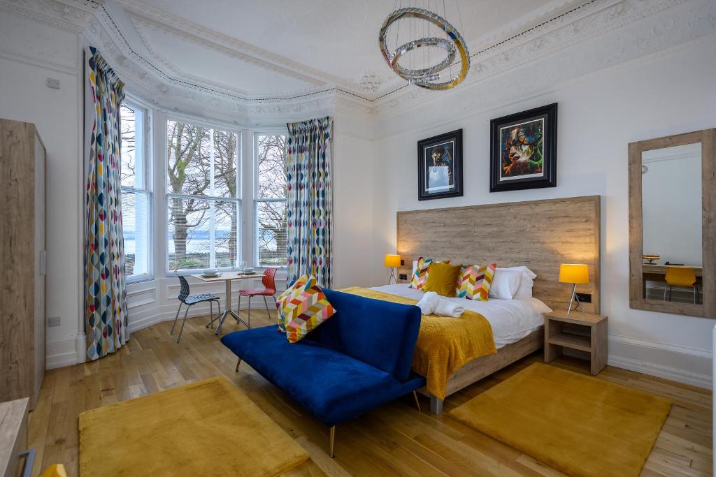 - une chambre avec un lit king-size et une chaise bleue dans l'établissement The Clarendon, à Dundee