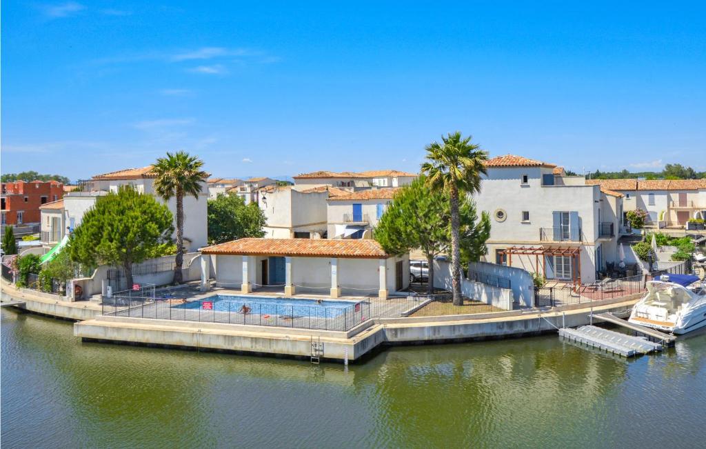 una casa con piscina junto a un cuerpo de agua en 3 Bedroom Nice Home In Aigues-mortes, en Aigues-Mortes