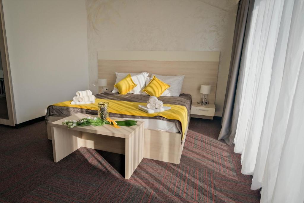 a bedroom with a bed with yellow sheets and a table at Hotel Bor in Krk