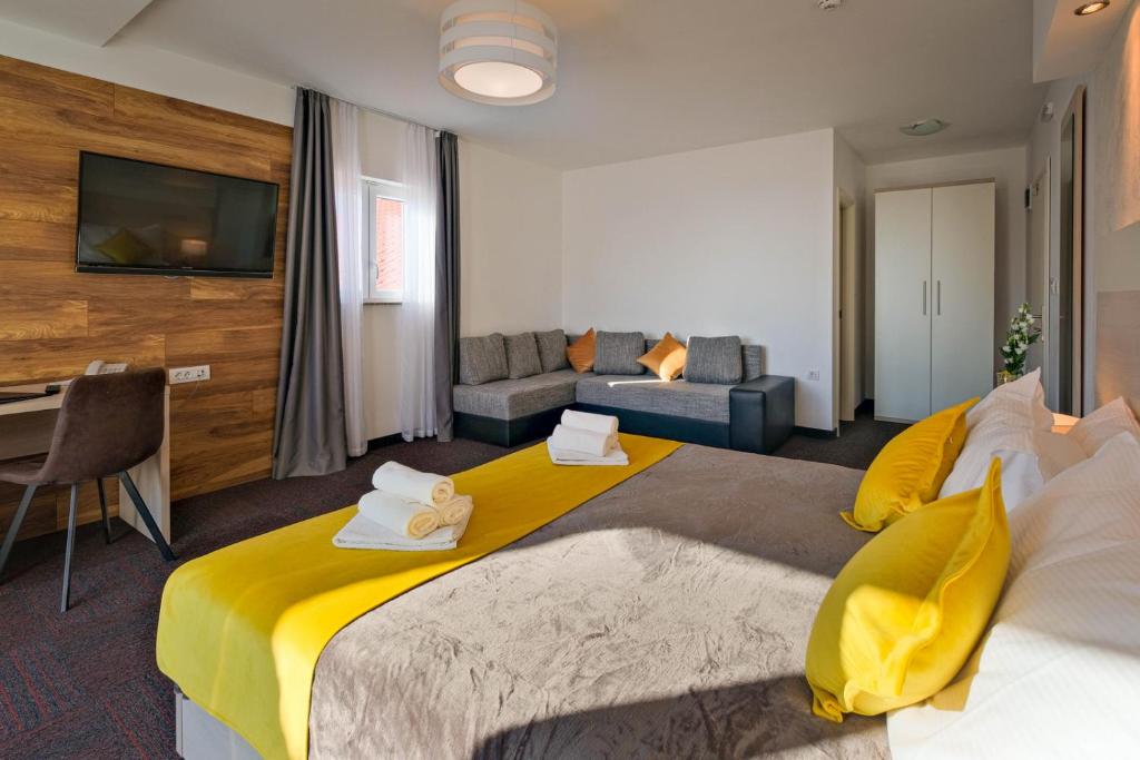 a hotel room with a large bed and a couch at Hotel Bor in Krk