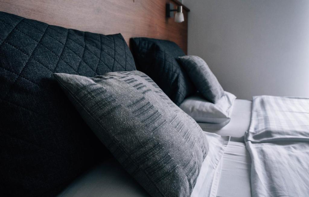 レンティにあるLenti Thermal Panzióのグレーの枕が付いたベッド1台が備わる客室です。