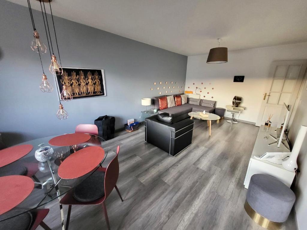 a living room with a couch and a table and chairs at Tichnich Apartement - 2 bedrooms in Annemasse