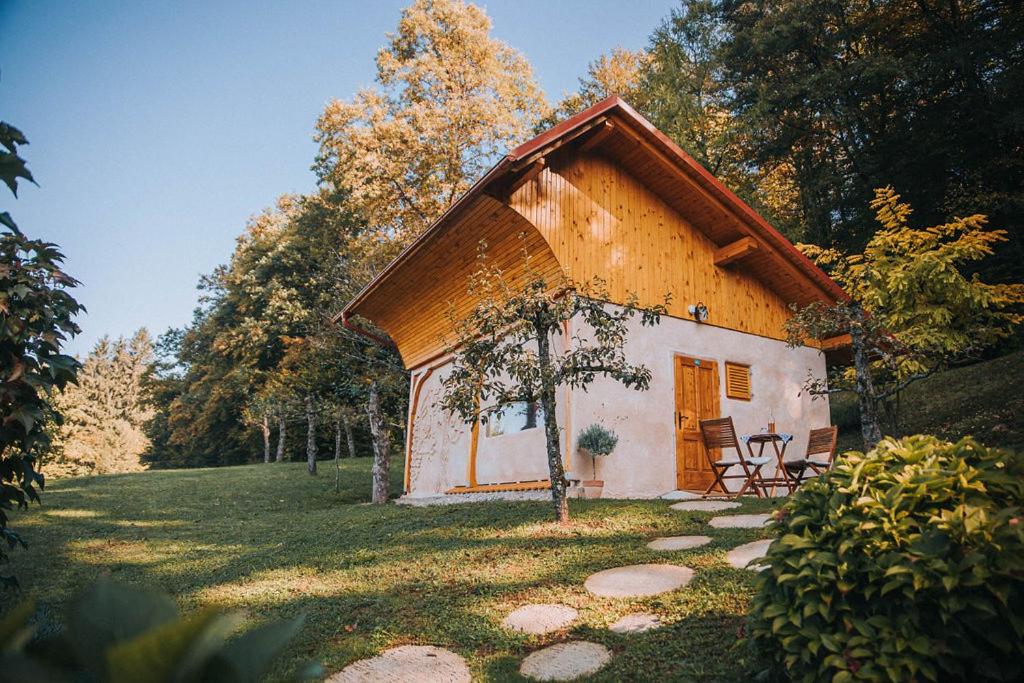 ein kleines Haus mit einem Stuhl im Hof in der Unterkunft Sleeping with bees - Tourist farm Muha in Grosuplje