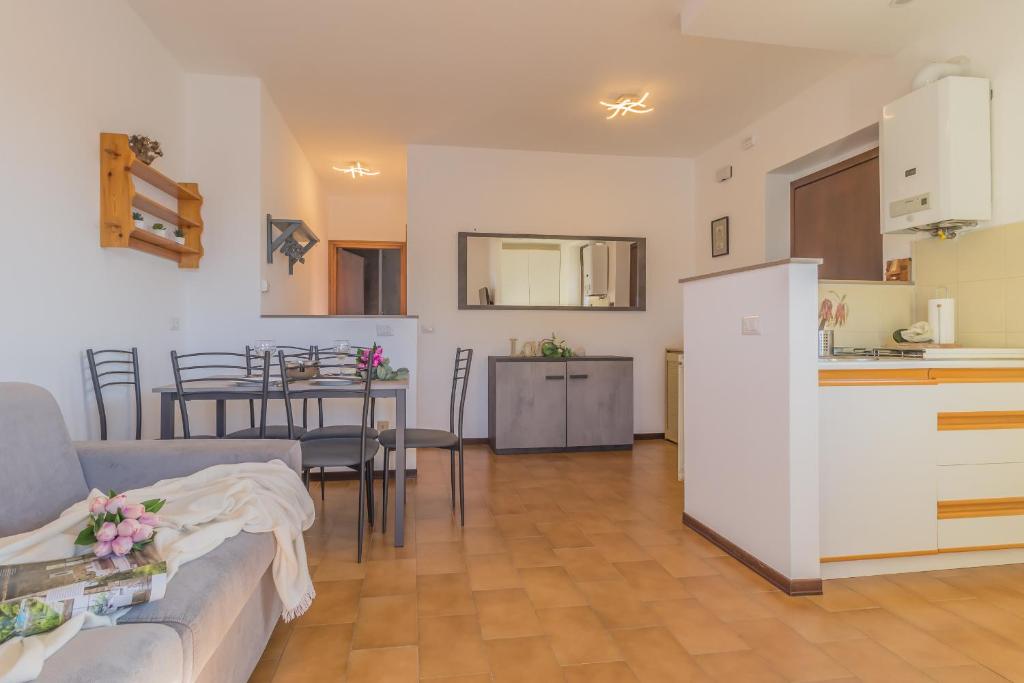 kuchnia i salon z kanapą i stołem w obiekcie Angolo con Vista w mieście Varenna