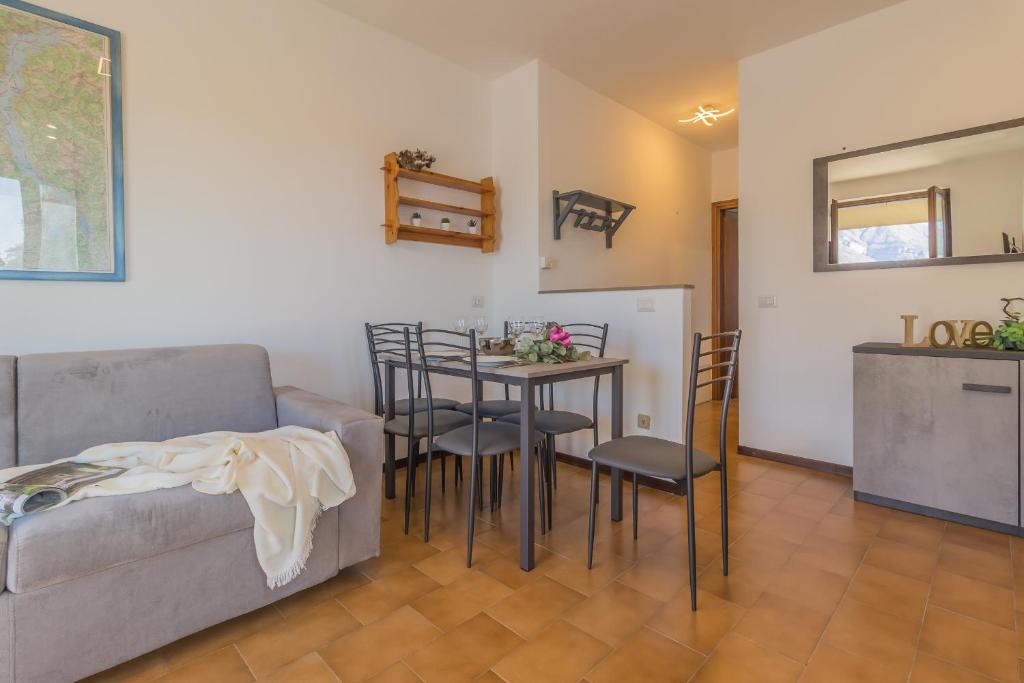 salon z kanapą, stołem i krzesłami w obiekcie Angolo con Vista w mieście Varenna