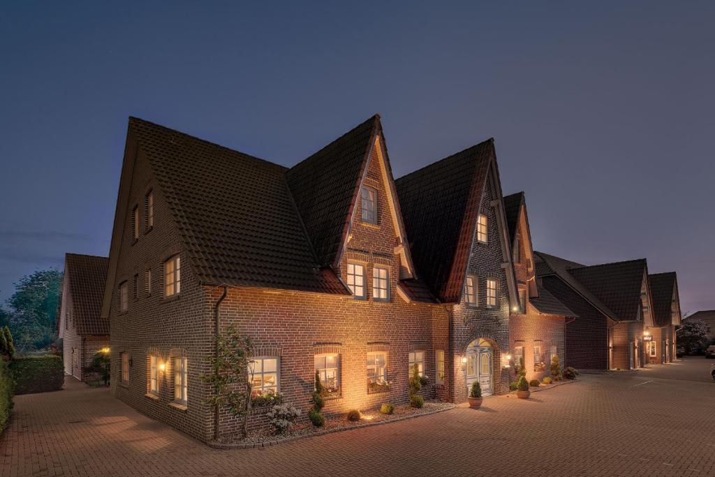 un grand bâtiment en briques avec un toit en gambrel dans l'établissement Der Romantik-Hof Greetsiel, à Greetsiel