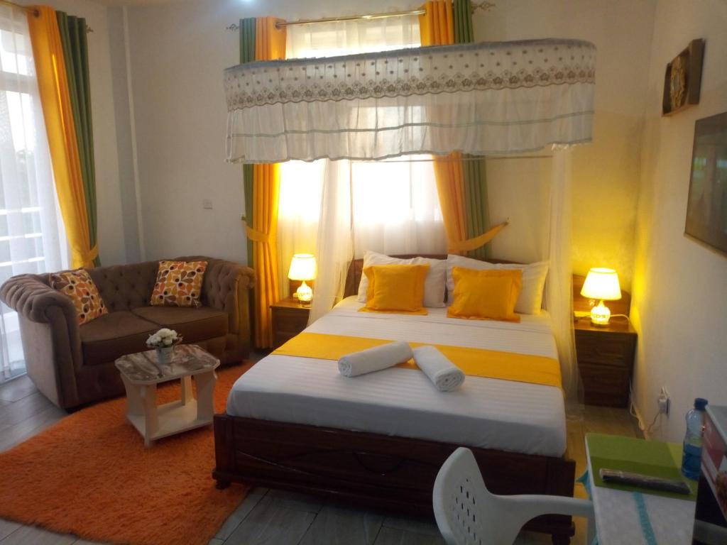 a bedroom with a bed and a couch in a room at Pride Studio Mtwapa in Mombasa