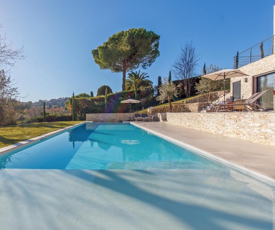 a swimming pool in front of a house at Villa SOHA Bed & Breakfast in Mougins