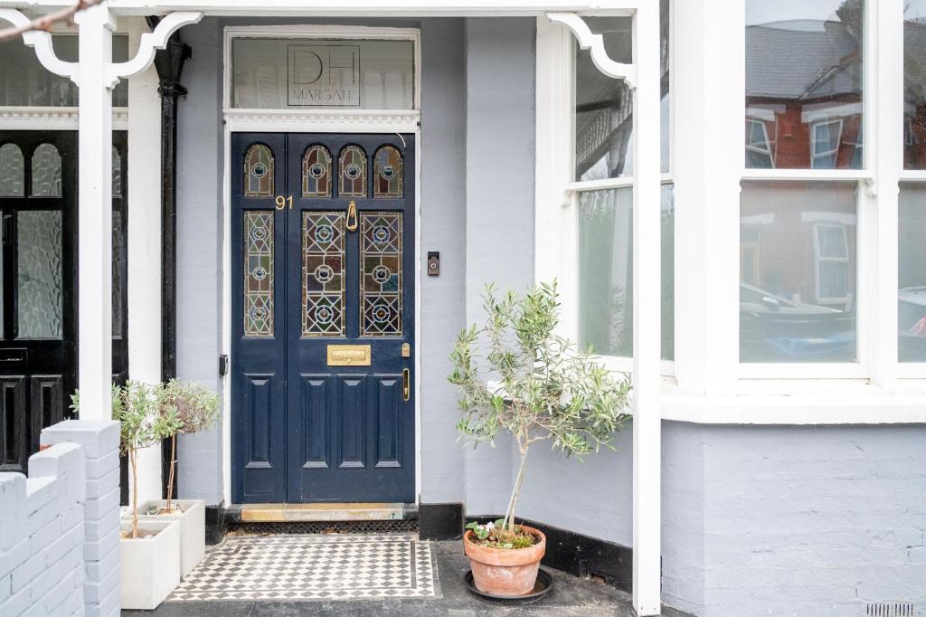 uma porta azul da frente de uma casa branca em Doghouse Margate em Kent