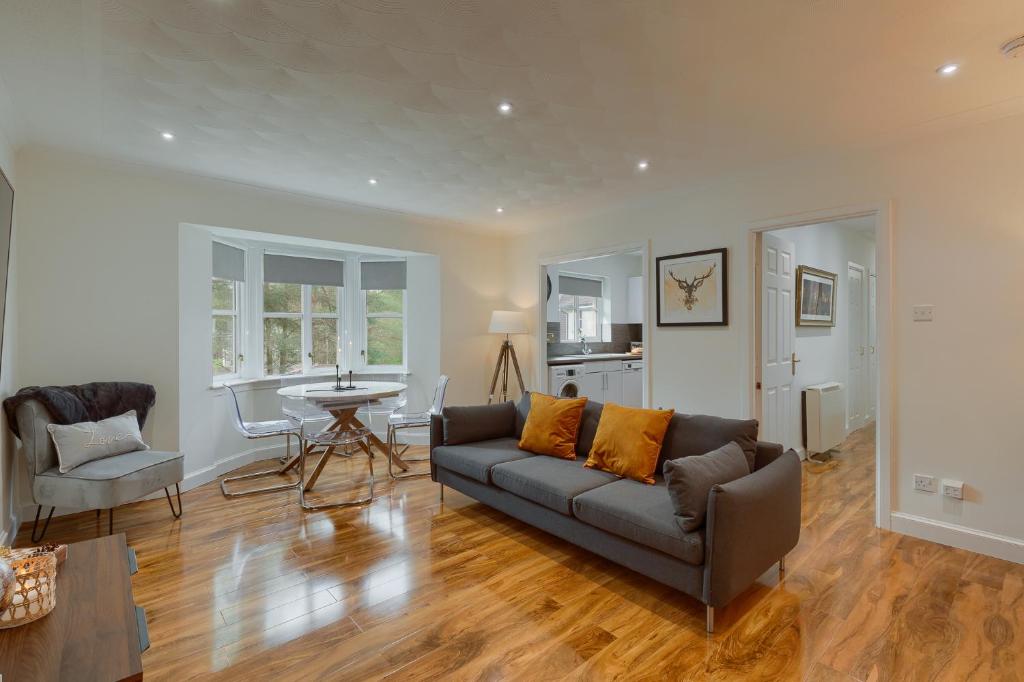 un soggiorno con divano e tavolo di 3 bedroom Windsor Garden apartment by Gleneagles a Blackford