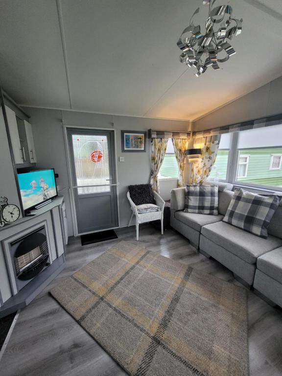 a living room with a couch and a tv at Cairnryan Heights 2 Bed caravan holiday home in Stranraer